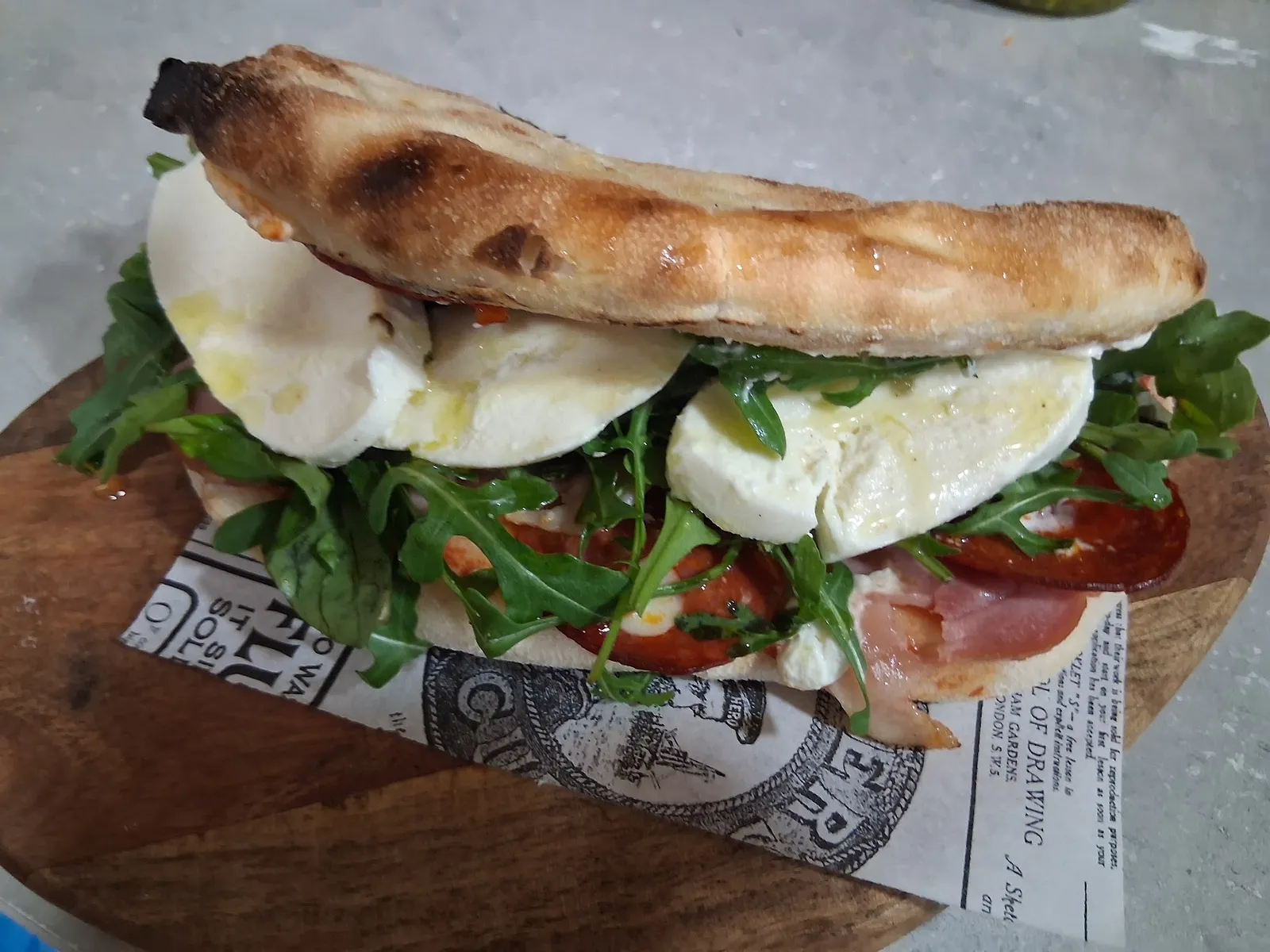 Pinsa con mozzarella, rúcula y jamón